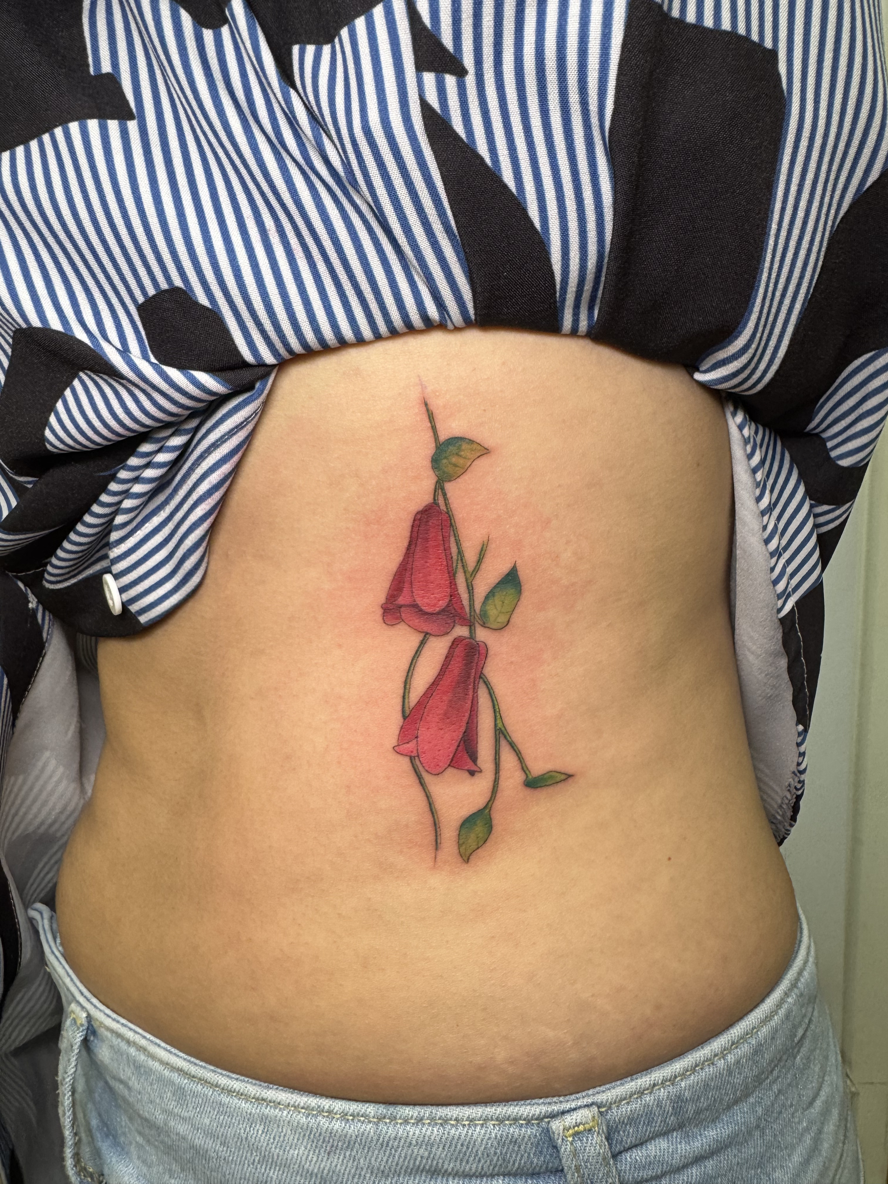 Tatuaje copihue color realista abdomen — CAOS Art Tattoo Chile